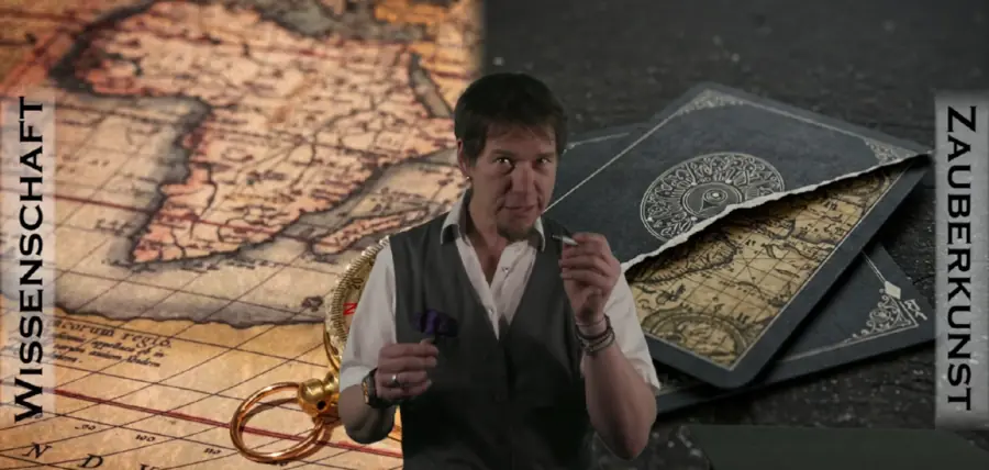 Markus Pfeil vor einer alten Landkarte und schwarzen Spielkarten, links und rechts die Schriftzüge Wissenschaft und Zauberkunst